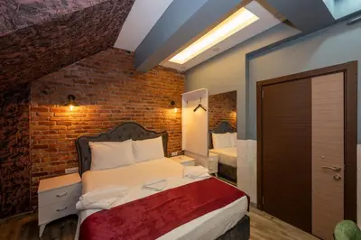 a bedroom with a bed with a brick wall at Taksim Story Residence in Istanbul