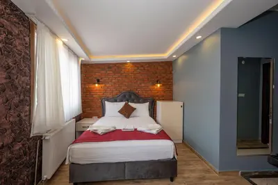 a bedroom with a bed and a brick wall at Taksim Story Residence in Istanbul