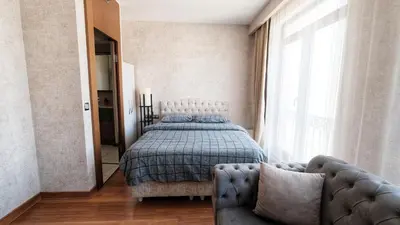 a bedroom with a bed and a couch and a window at İstanbul Houses Sabiha Gökçen Airport in Istanbul