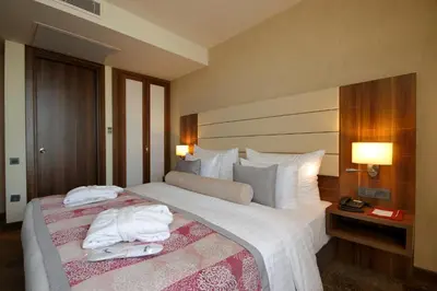 a hotel room with a large bed with towels on it at Tuyap Palas in Istanbul