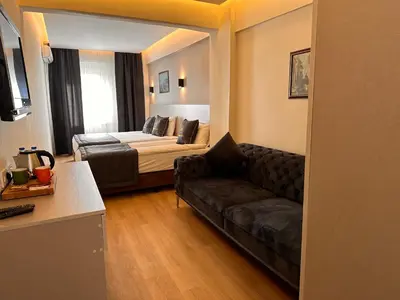a living room with a couch and a bed at HARRAN HOTEL in Istanbul