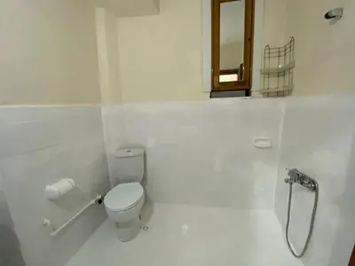 a white bathroom with a toilet and a window at 2 bedrooms central area located appartment 2 floor in Istanbul