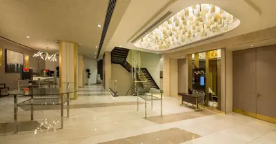 a lobby with a glass table and a staircase at Hilton Istanbul Kozyatagi in Istanbul