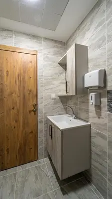 a bathroom with a sink and a wooden door at KUMBAĞ ŞEHRİ SARAY APART OTEL in Tekirdag