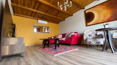 a living room with a red couch and a table at KİRAZ BEACH OTEL in Erdek