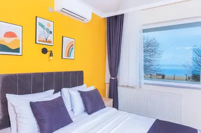 a bedroom with a bed and a large window at KİRAZ BEACH OTEL in Erdek