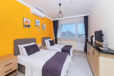 a hotel room with two beds and a television at KİRAZ BEACH OTEL in Erdek
