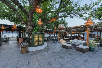 a patio with couches and a tree with lights at KİRAZ BEACH OTEL in Erdek