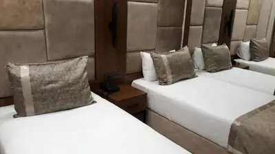 two beds in a hotel room with white sheets at Four Sides Beyoglu in Istanbul