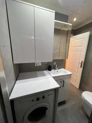 a white kitchen with a sink and a washing machine at Middle Village in Istanbul