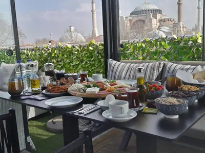 a table with food on a balcony with a view of a mosque at Armagrandi Spina Hotel-Special Category in Istanbul