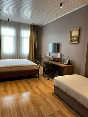 a room with two beds and a desk with a piano at Armagrandi Spina Hotel-Special Category in Istanbul