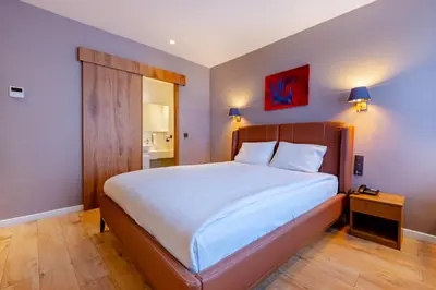 a bedroom with a large bed with a wooden headboard at Armagrandi Spina Hotel-Special Category in Istanbul