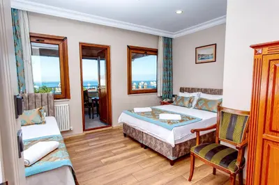 a bedroom with a bed and a chair and windows at Hotel Saba in Istanbul