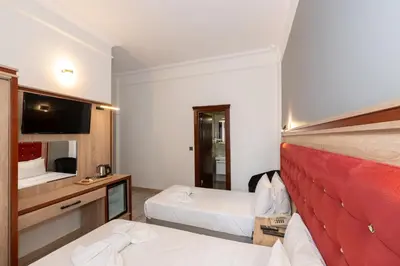 a hotel room with two beds and a television at Olimpic Hotel in Istanbul
