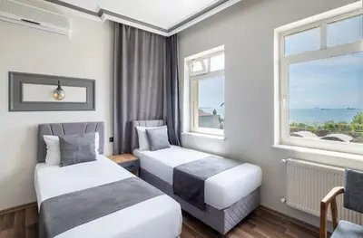two beds in a room with two windows at Sur Hotel Sultanahmet in Istanbul