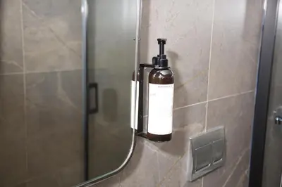 a bottle of soap in a bathroom mirror at Yusufpasa Konagi - Special Class in Istanbul