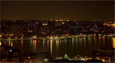 a view of a city at night with lights on the water at Hotel Troya in Istanbul