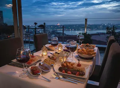 a table with plates of food and wine glasses at Hotel Troya in Istanbul