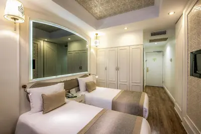 a bedroom with two beds and a mirror at Hotel Yasmak Sultan in Istanbul