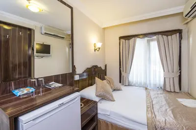 a small bedroom with a bed and a mirror at Naz Wooden House Inn in Istanbul