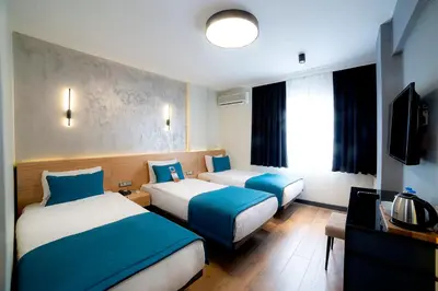 a hotel room with two beds and a television at Barin Hotel in Istanbul