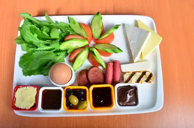 a tray of food with cheese and vegetables on a table at Barin Hotel in Istanbul