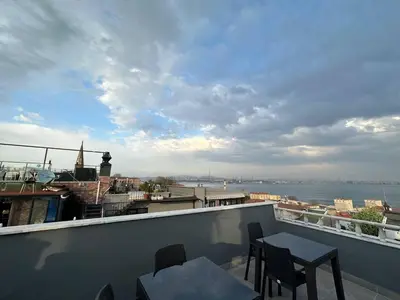 a balcony with tables and chairs and a view of the water at Hanedan Hotel in Istanbul