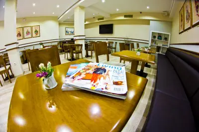 a restaurant with a table with a magazine on it at Ilkay Hotel in Istanbul