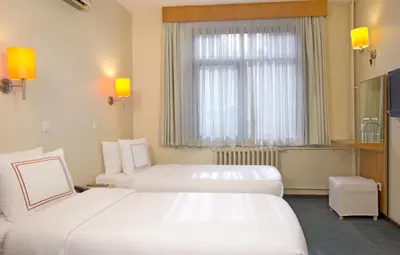 a hotel room with two beds and a window at Ilkay Hotel in Istanbul