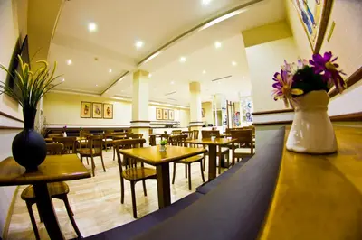 a restaurant with tables and chairs and flowers on the counter at Ilkay Hotel in Istanbul