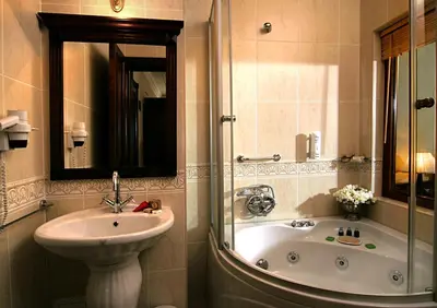 a bathroom with a sink and a tub and a mirror at Dersaadet Hotel Istanbul in Istanbul