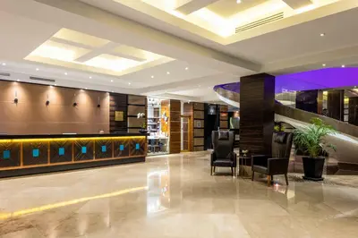 a lobby of a hotel with chairs and a bar at Hotel Çelik Palas Convention Center & Thermal SPA in Bursa