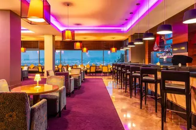 a restaurant with tables and chairs and a bar at Hotel Çelik Palas Convention Center & Thermal SPA in Bursa