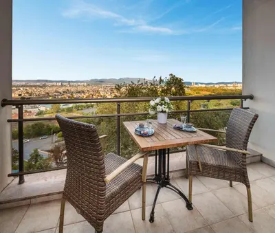 a table and chairs on a balcony with a view at Hotel Çelik Palas Convention Center & Thermal SPA in Bursa