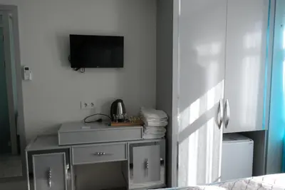 a room with a tv on a white wall with a table at Star Holiday Hotel in Istanbul