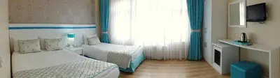 a hotel room with two beds and a television at Star Holiday Hotel in Istanbul