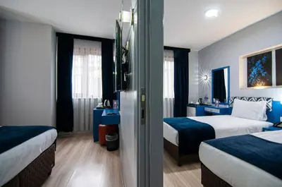 two beds in a hotel room with blue walls at Lapis Inn Hotel & Spa ( Ex. Ambassador Hotel) in Istanbul