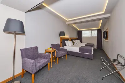 a hotel room with a bed and a couch and chairs at Bergama Hotel Old City in Istanbul
