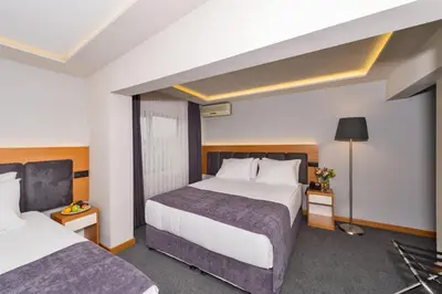 a hotel room with two beds and a lamp at Bergama Hotel Old City in Istanbul