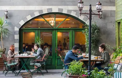 a group of people sitting at tables outside a restaurant at Garden House Hotel - Special Class in Istanbul