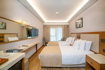 a hotel room with two beds and a desk at Erboy Hotel Istanbul Sirkeci in Istanbul