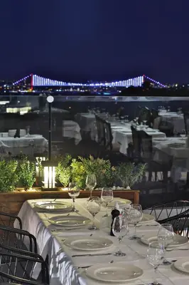 a table with wine glasses and a view of a bridge at Orient Express & Spa by Orka Hotels in Istanbul
