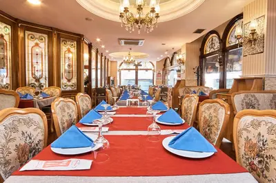 a dining room with a long table with blue napkins at Best Western Empire Palace Hotel & Spa in Istanbul