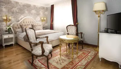a bedroom with a bed and a table and chairs at Best Western Empire Palace Hotel & Spa in Istanbul