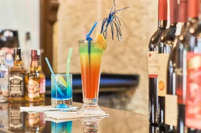 two cocktails sitting on a bar with bottles of wine at Best Western Empire Palace Hotel & Spa in Istanbul