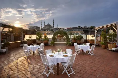a patio with white tables and chairs on a roof at Armada Istanbul Old City Hotel in Istanbul