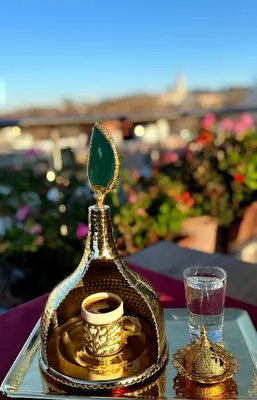 a gold teacup and a cup of coffee on a table at Golden Horn Hotel in Istanbul