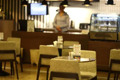 a person standing in a restaurant with tables and chairs at Antik Hotel Istanbul in Istanbul