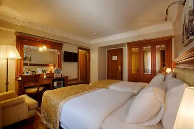 a hotel room with two beds and a desk and a desk at Hotel Sumengen in Istanbul